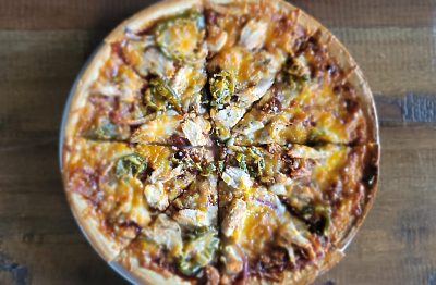 Meat and vegetable pizza on a round plate